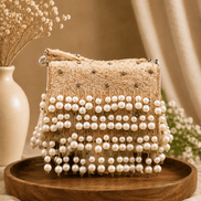 Pink woven pearl shoulder bag with layered bead bands and dangling pearl tassel trim