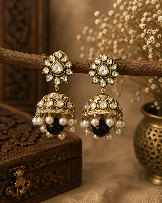 Gold-tone kundan jhumka earrings with green centers, pearl fringe, and blackish drops