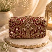 Wine red embellished clutch with gold beadwork and hinged clasp, front view