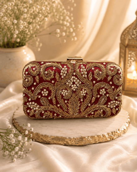 Wine red embellished clutch with gold beadwork and hinged clasp, front view