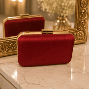 Wine red textured clutch with gold top clasp, side view