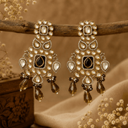 Chandbali earrings with gold-tone kundan, black center, clear stones and amber drops.