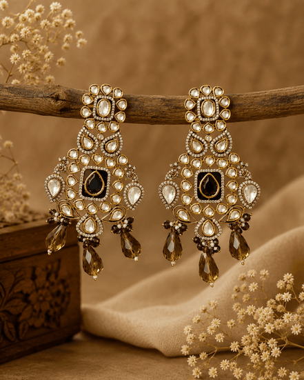 Chandbali earrings with gold-tone kundan, black center, clear stones and amber drops.