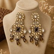 Golden chandbali earrings with kundan setting, dark center, amber and purple drops.