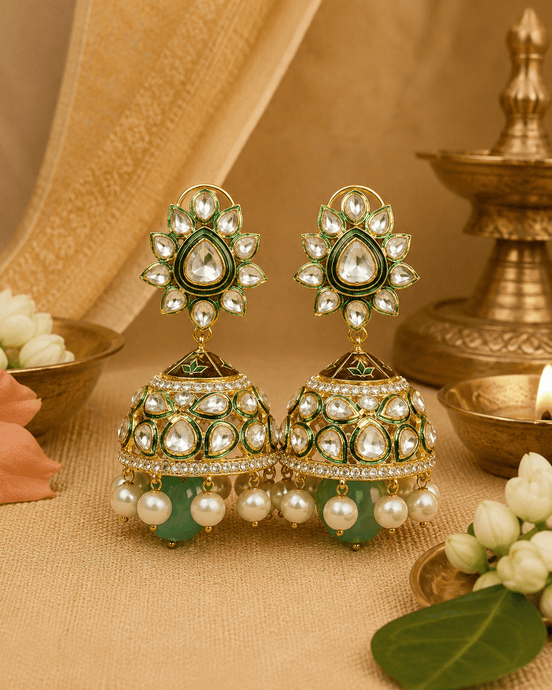 Gold-tone kundan jhumka earrings with green centers and pearl fringe, teal drops