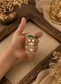 Gold Kada bracelet with green oval stones and three round pearl settings