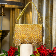 Gold crystal shoulder bag with top handle and dense beaded fringe