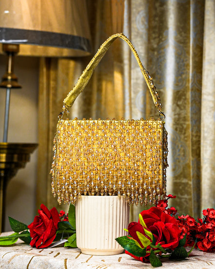 Gold crystal shoulder bag with top handle and dense beaded fringe
