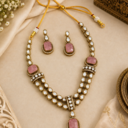Gold kundan necklace set with pink teardrop pendants, pearl bead rows, and matching earrings