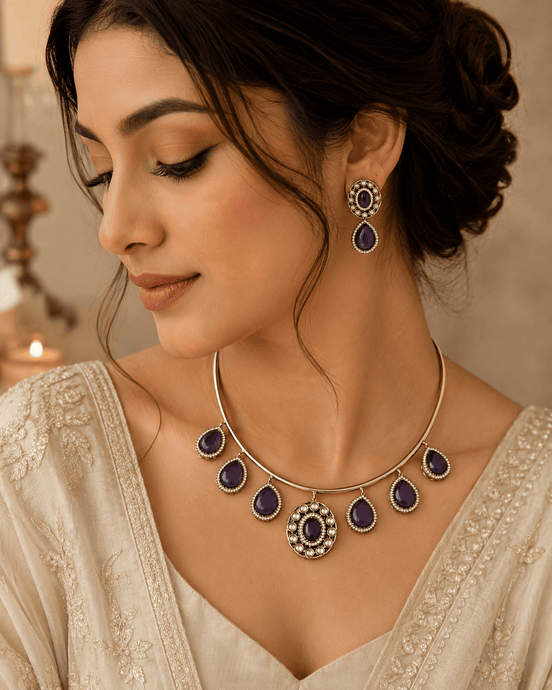 Gold-tone necklace with purple teardrop drops and matching earrings