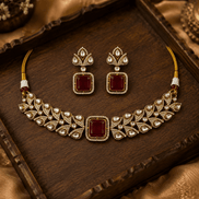Gold-tone choker necklace with ruby-pink square pendant stones and matching dangling earrings.