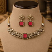 Gold-tone choker set with ruby-pink square stones and stud drop earrings on necklace stand.