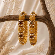 Gold-tone heritage bangles set with green stone accents and round filigree discs