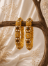 Gold-tone heritage bangles set with green stone accents and round filigree discs