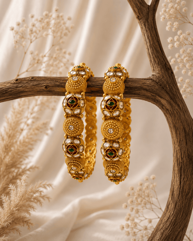 Gold-tone heritage bangles set with green stone accents and round filigree discs