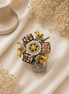 Ornate floral cuff bracelet with gold beads, colorful enamel squares, and jeweled center