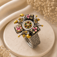 Wide silver-tone cuff with round jeweled center, enamel flower panels, and gold accents