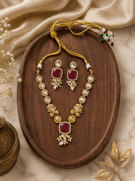 Gold-toned necklace set with ruby red square pendant and floral pearl earrings