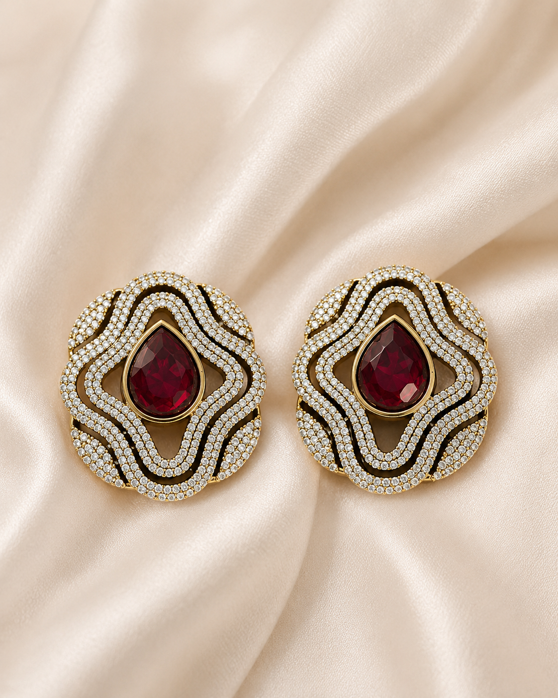Brass-tone statement stud earrings with red teardrop center and layered crystal trim