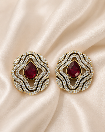Brass-tone statement stud earrings with red teardrop center and layered crystal trim