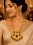 Gold-tone jewelry set: necklace with kundan pendant and dangling earrings on model