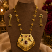 Gold-tone necklace with kundan teardrop pendant and drop earrings on display bust