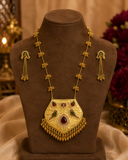 Gold-tone necklace with kundan teardrop pendant and drop earrings on display bust