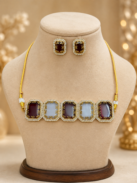 Gold-tone beaded choker with alternating dark and light square enamel links on bust