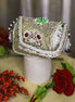 Beige jeweled box clutch with ornate front frame, pearl-like bead fringe, short handle