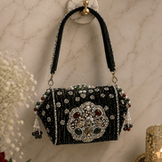 Black beaded box clutch with ornate centerpiece and dangling tassel details
