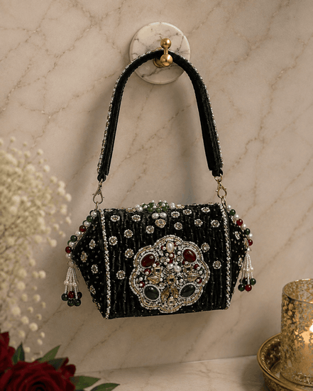 Black beaded box clutch with ornate centerpiece and dangling tassel details