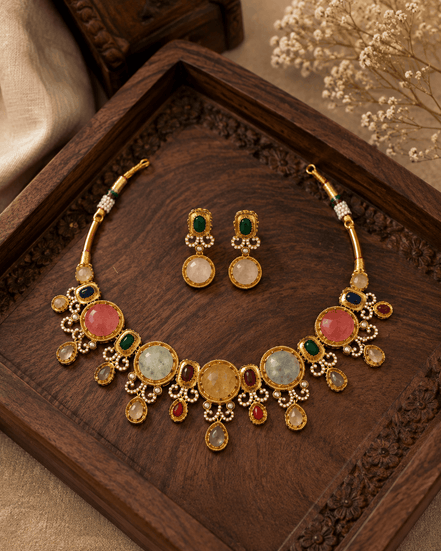 Gold-tone necklace and earrings set with round gemstone drops and oval center stones