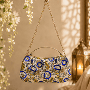 Beige floral clutch bag with blue and gold medallion pattern and chain handle