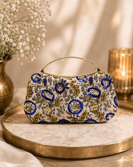 Beige floral clutch bag with blue and gold ornaments and curved top handle
