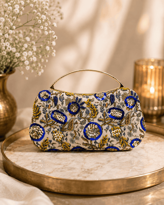 Beige floral clutch bag with blue and gold ornaments and curved top handle