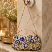 Beige clutch bag with blue floral pattern and gold chain, half-moon top handle