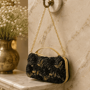 Black fabric floral clutch bag with gold embroidered flowers and top handle