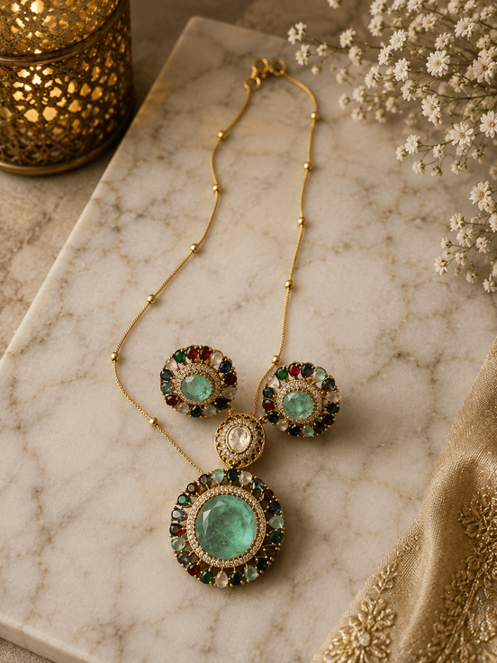 Gold-tone jewelry set with round stud earrings and large teal center circular pendant