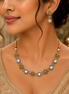 Gold-tone necklace with geometric white accents and matching drop earrings