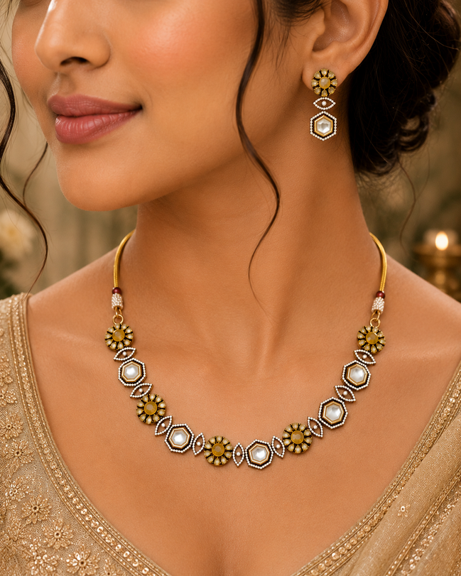 Gold-tone necklace with geometric white accents and matching drop earrings