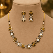 Gold-tone necklace set on mannequin with geometric pendant necklace and drop earrings