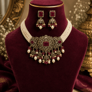 Burgundy velvet display with wine choker necklace, pearl tassels, and drop earrings