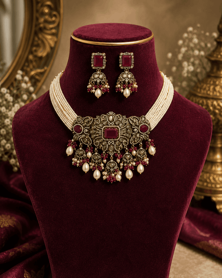 Burgundy velvet display with wine choker necklace, pearl tassels, and drop earrings