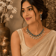 Teal and gold necklace set with matching earrings worn on model