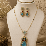 Gold-tone gemstone pendant necklace set with teal diamond pendant and matching drops