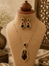 Gold-tone pendant necklace set with dark red, green, and purple gemstone drops