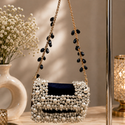 Pearl-beaded mini bag with navy insert and long tassel strands on gold chain