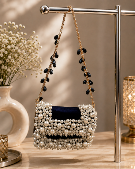 Pearl-beaded mini bag with navy insert and long tassel strands on gold chain