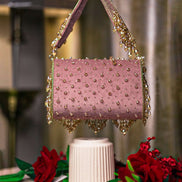 Pink beaded hobo bag with top handles and layered dangling fringe