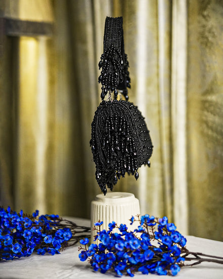 Black beaded hobo bag with vertical sequin texture and dangling fringe